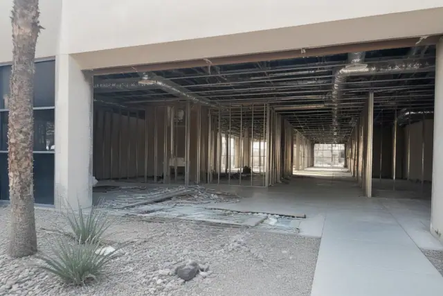 Interior of a commercial building demolition site showing exposed structural studs and utility conduits in Phoenix, AZ.