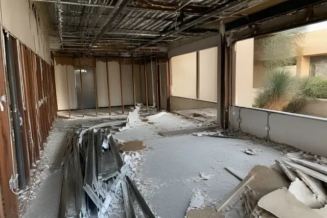 Interior of a commercial office space undergoing selective demolition in Phoenix, AZ with exposed studs and jobsite debris.