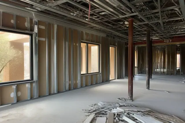 Interior commercial demolition site with exposed metal conduits and debris on the floor in Scottsdale, AZ.