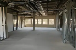 Interior of a commercial space with exposed structural metal studs and ceiling conduits in Phoenix, AZ.