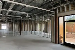 Interior of a commercial space with exposed structural studs and ceiling conduits after demolition in Phoenix, AZ.