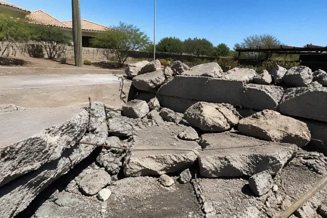 Broken concrete slab with exposed rebar during a demolition project in Goodyear, AZ.