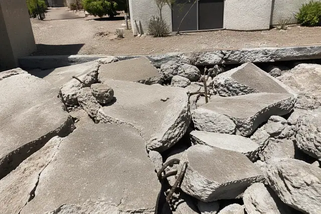 Broken concrete slab with exposed rebar during demolition at a jobsite in Glendale, AZ.