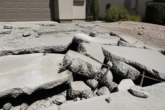 Broken concrete driveway slab with exposed rebar during a demolition project in Phoenix, AZ.