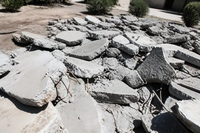 Full-slab mechanical demolition of a concrete pad with exposed rebar on a jobsite in Phoenix, AZ.