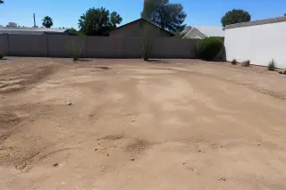 Cleared residential lot showing foundation impressions after garage demolition in Phoenix, AZ.