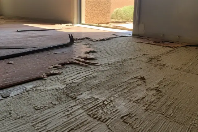Hardwood and engineered wood flooring removal with pry bars and splinters at a residential project in Phoenix, AZ.