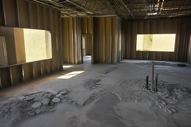 Interior office space under construction with exposed studs and concrete debris at a project site in Phoenix, AZ.