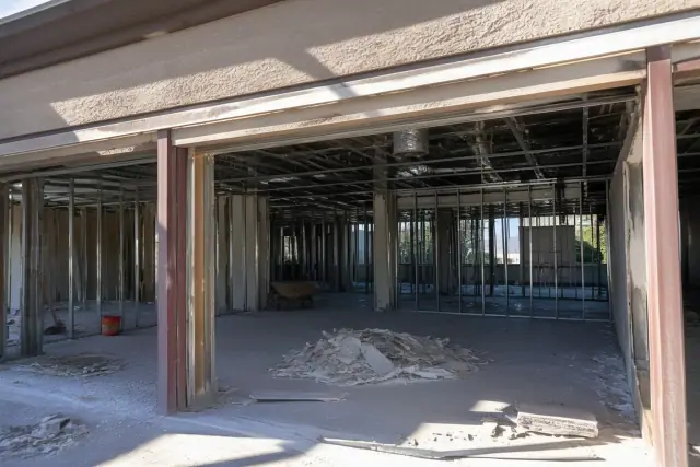 Interior demolition of a commercial office space with exposed studs and debris at a jobsite in Chandler, AZ.