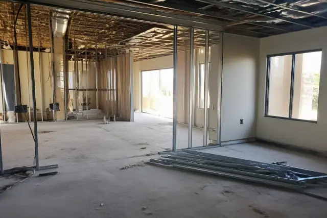 Interior demolition progress in a commercial office space with exposed studs and debris in Peoria, AZ.