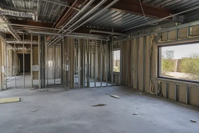 Interior of a commercial office gut in Surprise, AZ, showing exposed studs and utilities during a demolition project.