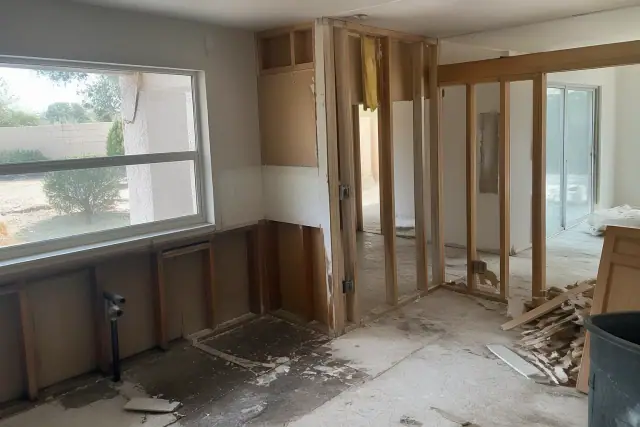 Kitchen demolition showing exposed wall framing and removed cabinets in a residential home in Phoenix, AZ.