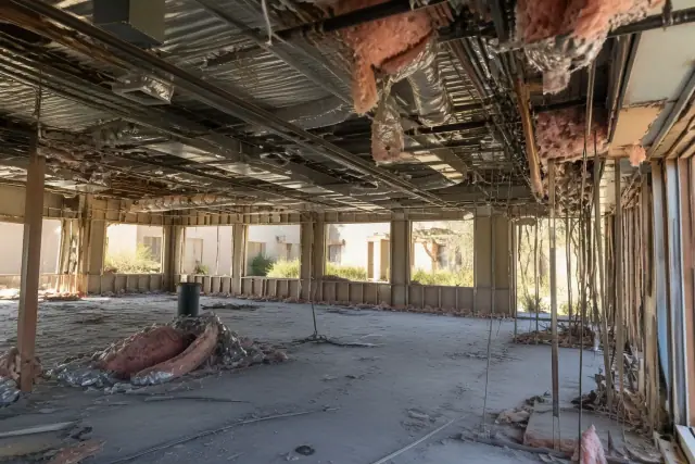 Interior demolition progress of a multi-story commercial site showing exposed studs and wires in Phoenix, AZ.