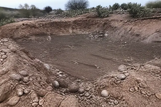 A hollowed pool basin filled with aggregate and soil during a demolition project in Mesa, AZ.