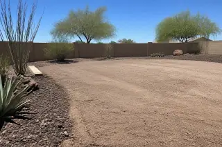 Level ground filled with compacted gravel where a pool was removed in a xeriscaped Phoenix, AZ yard.