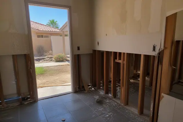 Interior of a residential home undergoing demolition with exposed wall framing in Glendale, AZ.