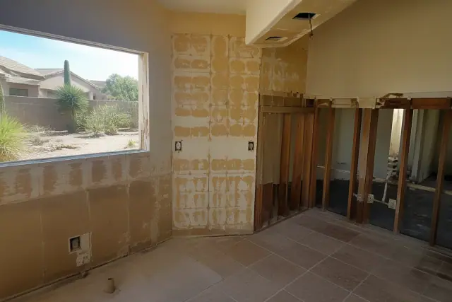 Interior of a house undergoing demolition with exposed wall framing in Goodyear, AZ.