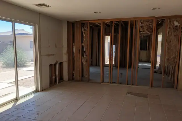 Residential demolition with exposed wall studs and insulation in a Tempe, AZ home.