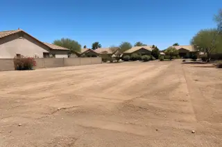 A leveled and cleared residential lot with smooth, graded dirt in a Phoenix, AZ neighborhood.