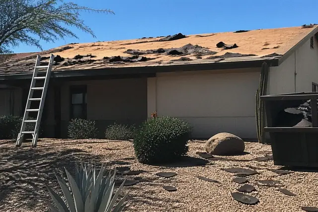 Torn shingles and exposed roof decking during a residential demolition project in Phoenix, AZ.