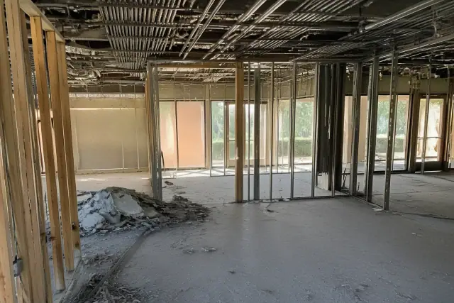 Interior of a commercial office during selective demolition with exposed studs and debris in Phoenix, AZ.