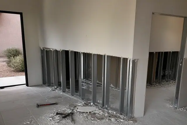 Interior wall with drywall removed and exposed metal studs during a gut renovation in Tempe, AZ.