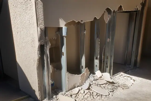 Partially dismantled drywall and metal studs during a structural demolition project in Phoenix, AZ.