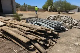 Sorted pile of wood, metal, and masonry waste on a cleaned demolition jobsite in Phoenix, AZ.