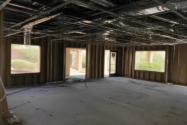 Interior of a commercial office gut showing raw structural studs and exposed conduits during a demolition in Phoenix, AZ.