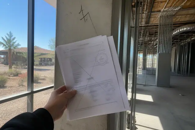 Utility disconnection notices held against a structural steel column in a gutted office building in Phoenix, AZ.