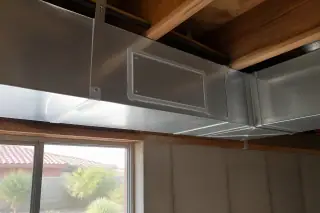 Cleaned silver metal ductwork with a new service access panel in a Phoenix, AZ basement.