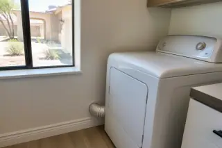 Cleaned clothes dryer with a connected, unkinked exhaust hose in a Phoenix, AZ laundry room.