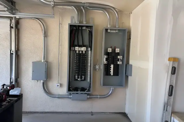 400 amp service upgrade with heavy conduit runs on a garage wall in Phoenix, AZ.