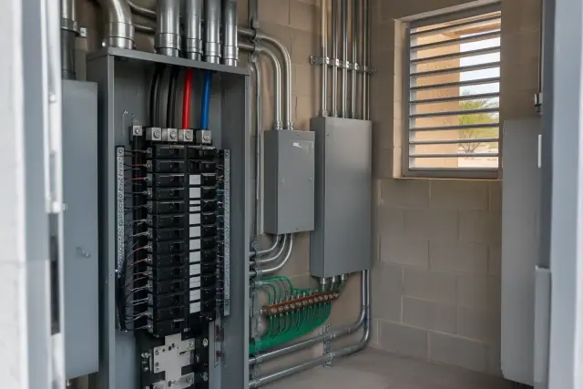 Commercial electrical panel upgrade in a utility room in Buckeye, AZ, showing heavy-gauge conduit and grounding.