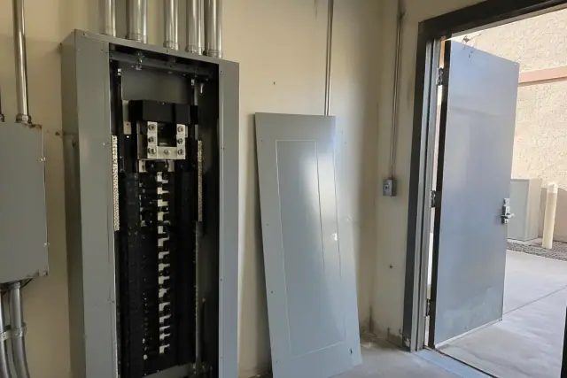 Commercial electrical panel upgrade inspection in Phoenix, AZ, showing an industrial panelboard and metal utility door.