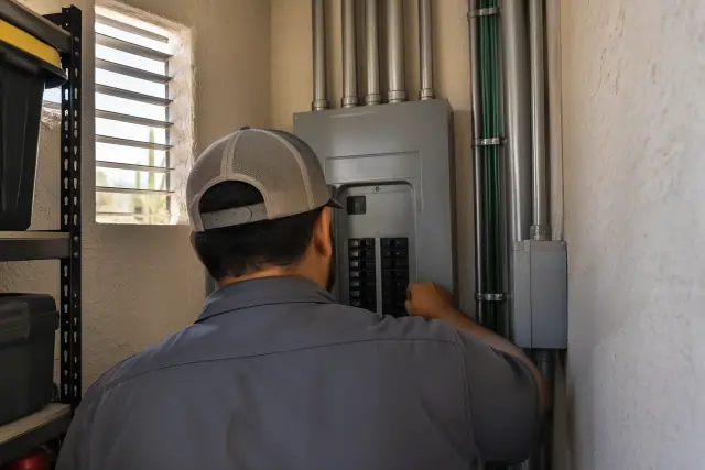 Electrical professional working on Coordinated Service equipment in a narrow storage space in Phoenix, AZ.