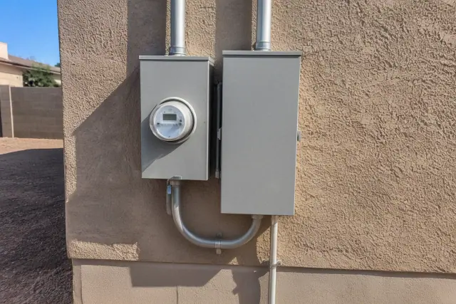Electrical panel and exterior meter socket on a stucco wall in Phoenix, AZ.