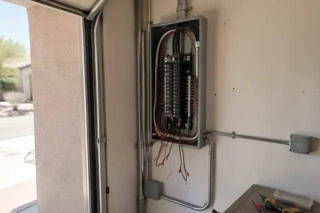 Electrical panel replacement with new breaker enclosure and conduit in a Tempe, AZ residential garage.