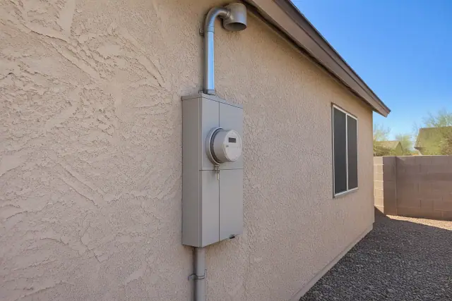 Meter box conduit and weatherhead mounted on a stucco wall in Phoenix, AZ.