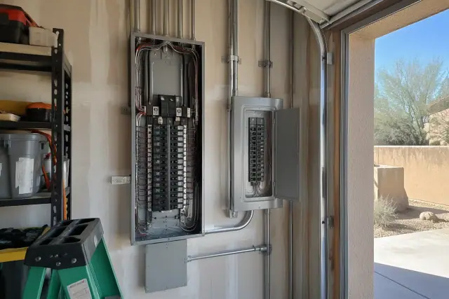 Subpanel installation in a residential garage in Scottsdale, AZ, showing terminated wires and a breaker enclosure.
