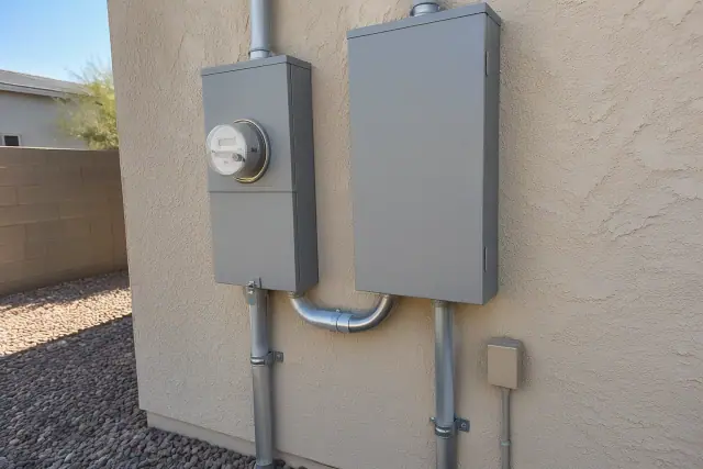 Targeted electrical panel repairs and new metal enclosure boxes on a stucco wall in Phoenix, AZ.