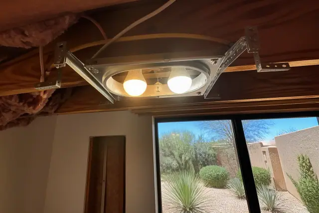 Two different color temperature light bulbs installed side-by-side in a Phoenix, AZ ceiling joist cavity.
