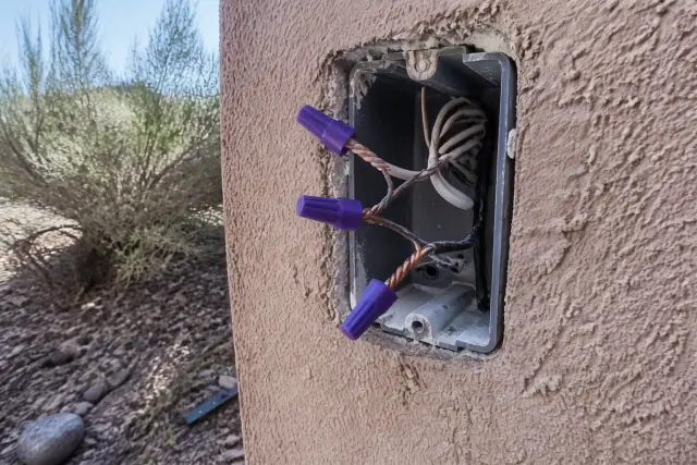 Copper pigtails joined to aluminum wiring with purple connectors in a Phoenix, AZ electrical wall box.