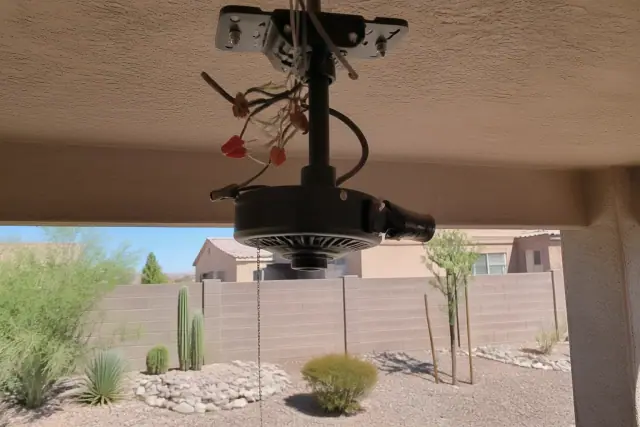 Electrician installing a ceiling fan mounting bracket and wiring in a home in Goodyear, AZ.