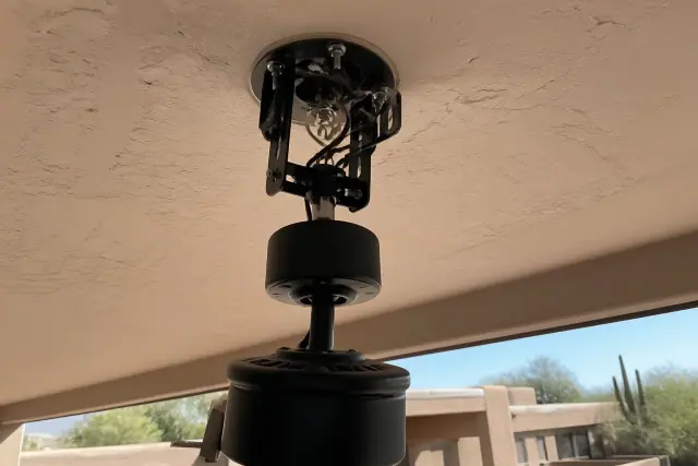 Technician installing a ceiling fan mounting bracket and wiring in a home in Phoenix, AZ.