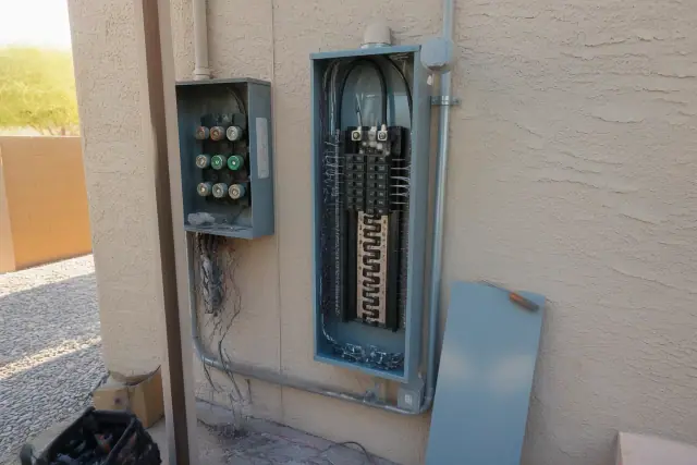 New electrical panel installation with labeled circuits and wiring on a stucco wall at a home in Mesa, AZ.