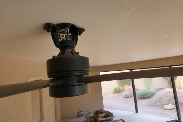 Technician installing a ceiling fan mounting bracket and housing in a home in Phoenix, AZ.