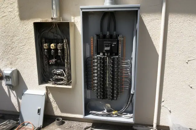 A new electrical panel replacing an old fuse cabinet on a stucco exterior wall in Phoenix, AZ.