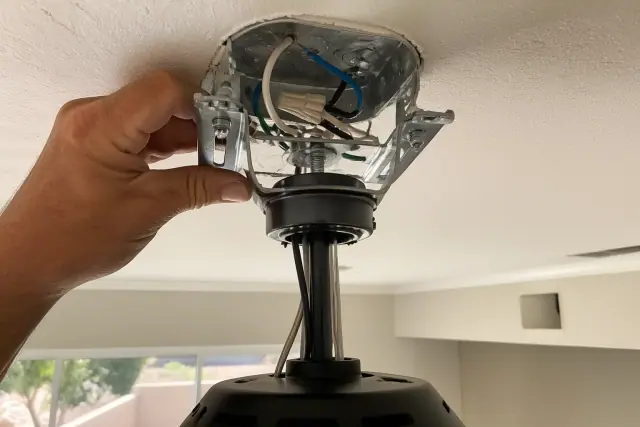 Technician installing a heavy-duty ceiling fan mounting bracket in a home in Phoenix, AZ.