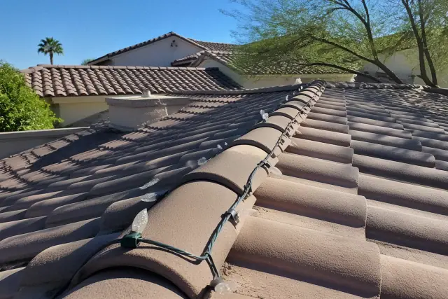 Holiday lights installed on a terracotta residential roofline in Phoenix, AZ.